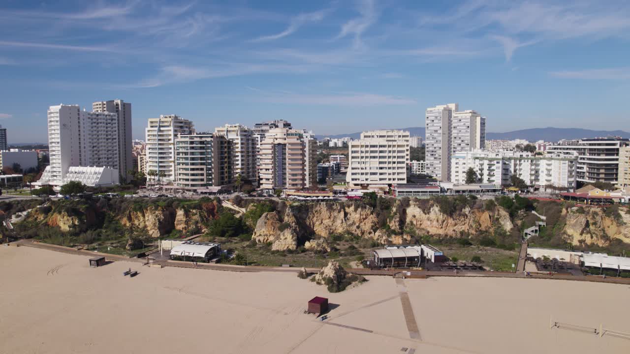 playa de arena turística popular praia da rocha y acantilados en portimao, edificios residenciales, volar hacia atrás