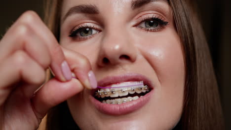 mujer limpiando sus aparatos ortopédicos con un cepillo interdental