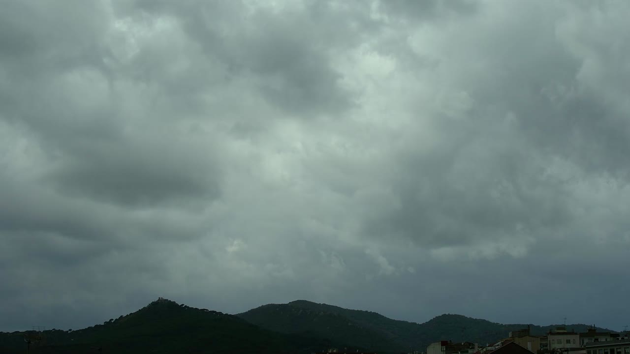 오후 에 도시 근처 의 산 들 을 지나가는 낮은 구름 의 시간 경과