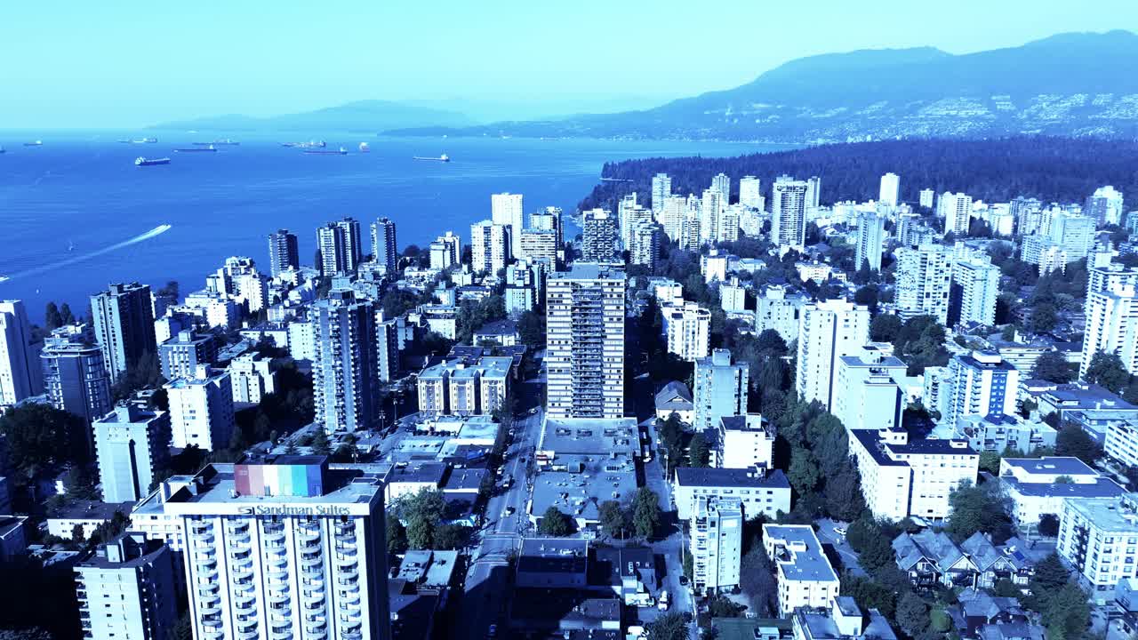 centro de vancouver sobrevuelo aéreo westend bandera gigante del arco iris en la azotea del hotel con vista a la comunidad lgbtq montañas del parque stanley envío cargueros en el horizonte lanchas recreativas disfruta el día