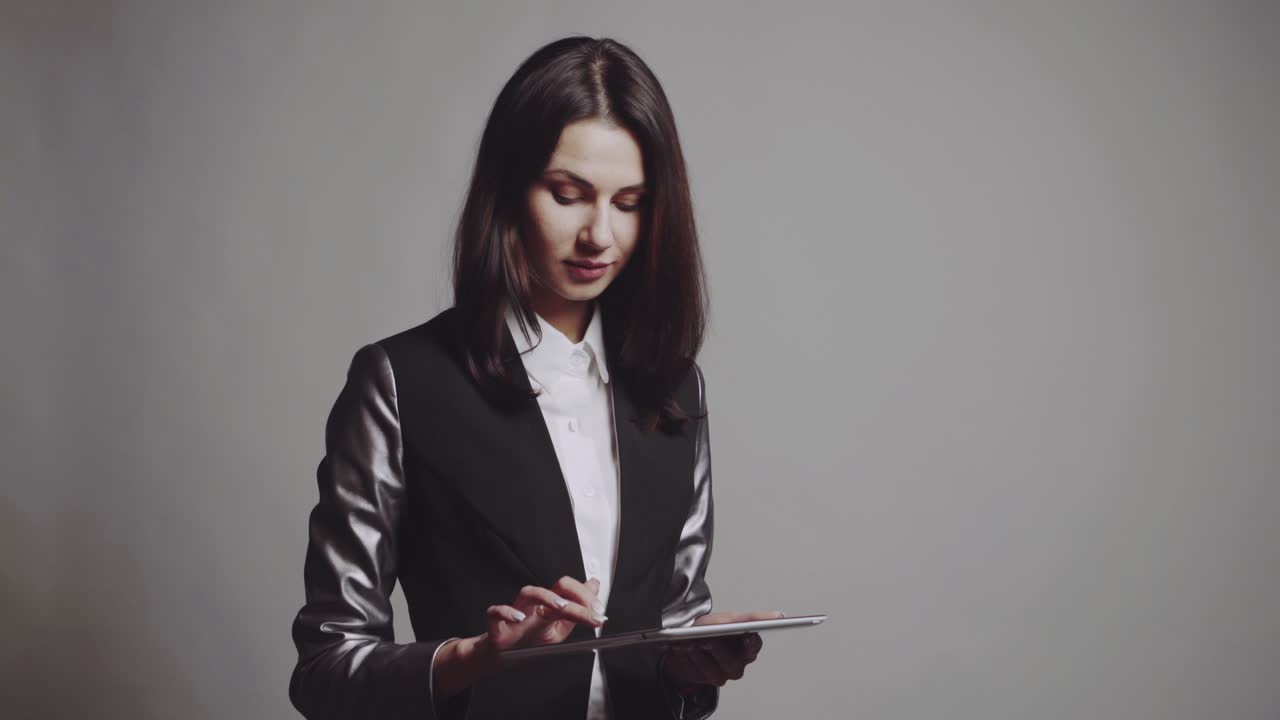 Woman using tablet. Business woman holding and using tablet in studio