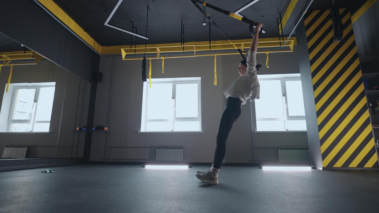 fitness TRX training exercises at gym woman push-up workout. Attractive woman doing exercise for hands in gym. core abs crossfit oblique training with fitness straps in the gym's studio. TRX