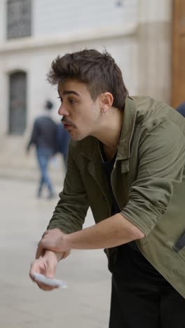 a man performs a magic trick with cards on the street