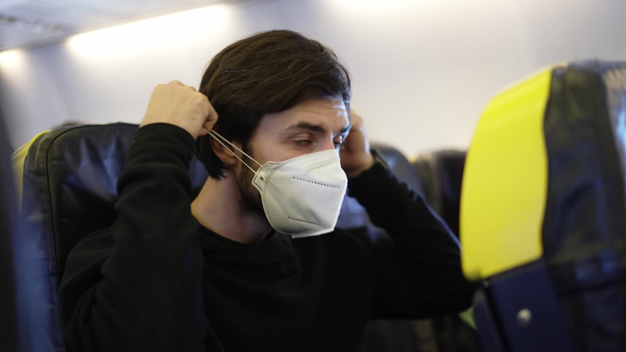 un hombre poniendo un masaje facial respiratorio, sentado en la tabla del avión