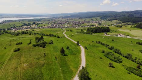 road through pastoral lands of summer meadow and southern poland village panoramic aerial