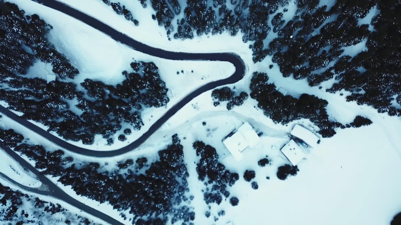 Aerial, a serpentine road in snowy Alps mountains in Austria