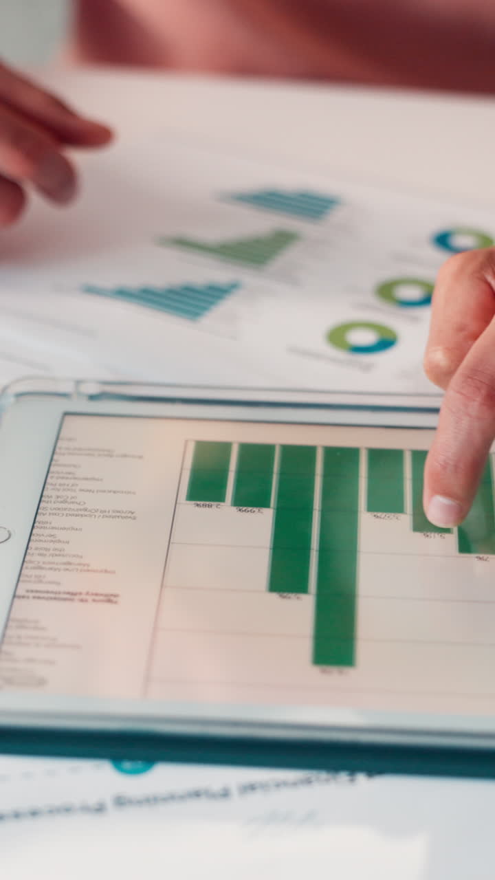 Nærbillede af hånd, der analyserer finansielle data på en digital tablet