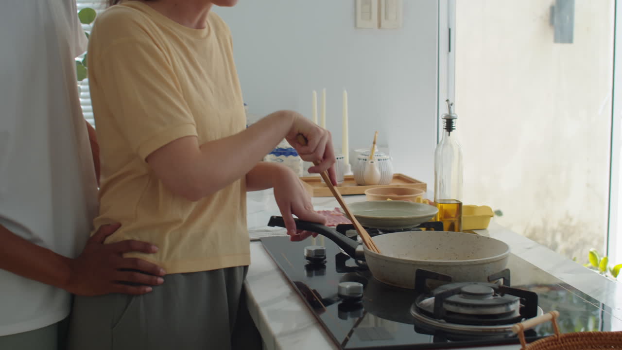 Diverse Spouses Kissing when Preparing Home Breakfast