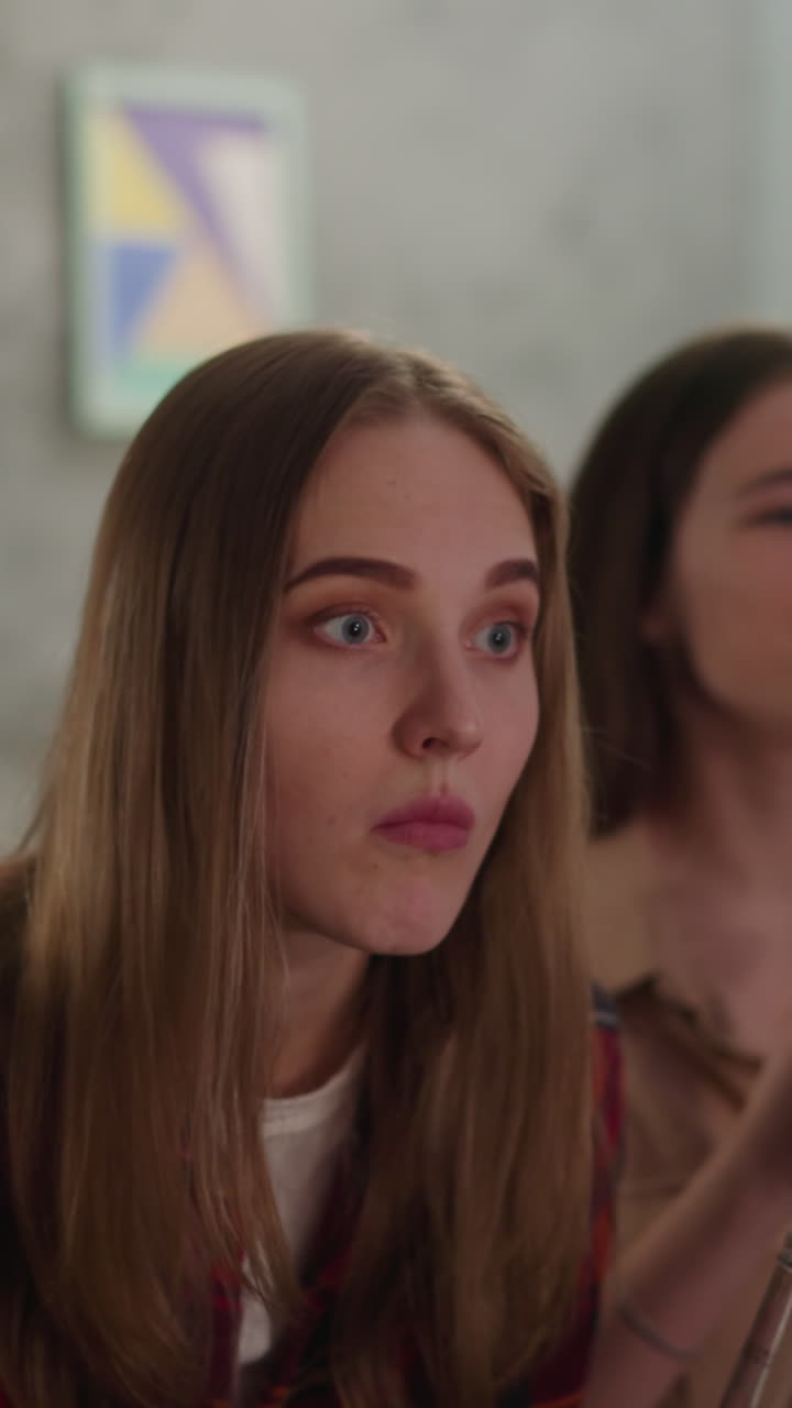 Pretty woman angry of failed attack throws chips to TV screen shocking friends at football match closeup slow motion. Students watch championship together