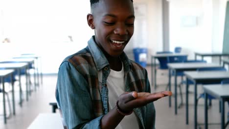 Schoolboy-looking-at-cupped-hand-in-classroom