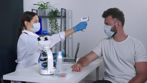 el médico comprueba la temperatura del paciente