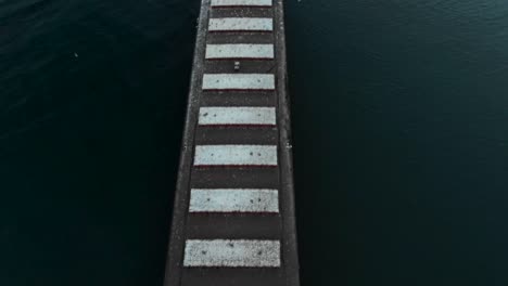 drone flying over a shipping container ship docked at a harbor on lake ontario