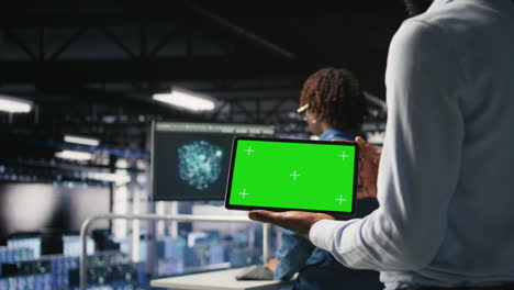 data center admin checking code on tablet next to colleague