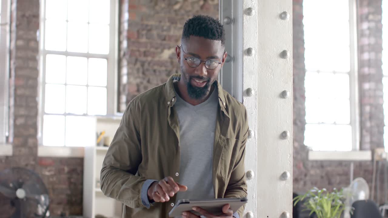 Portrait of happy african american casual businessman using tablet in slow motion