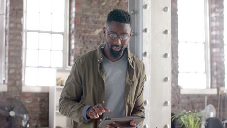 retrato de un feliz hombre de negocios afroamericano que usa una tableta en cámara lenta