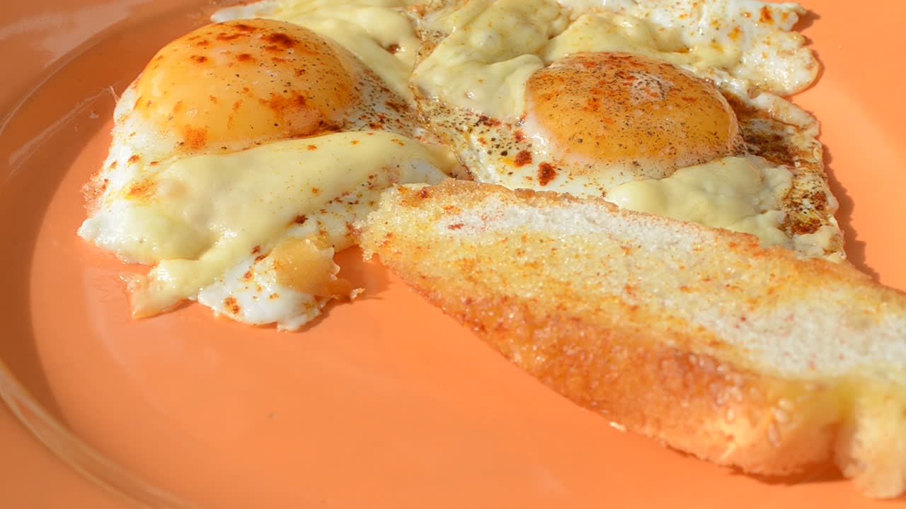 Uova fritte e panini su un piatto. Riprese in cucina. Processo di preparazione di un piatto.
