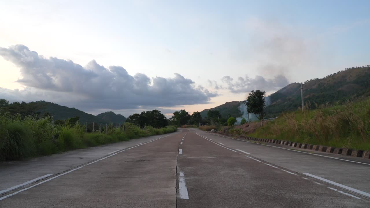 Woman walking on a road with mountains in the background