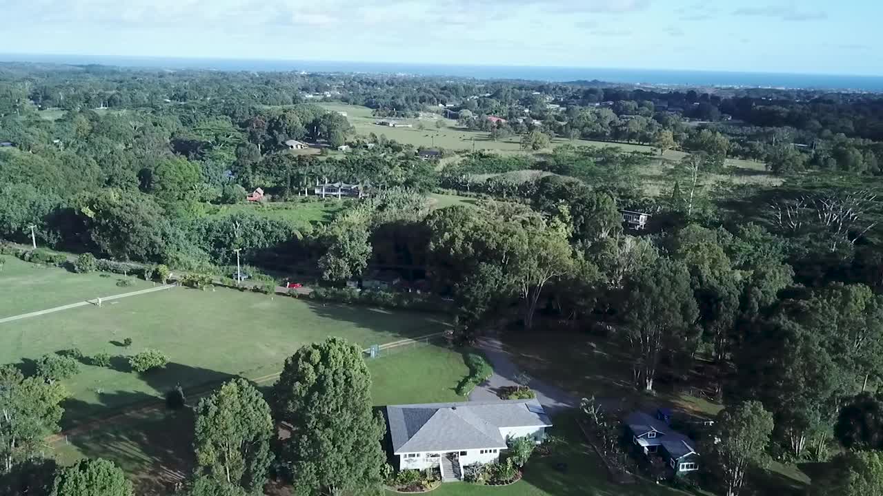 하와이의 킬라우에아에 있는 푸른 나무와 으로 둘러싸인 아름다운 집 - 공중 드론