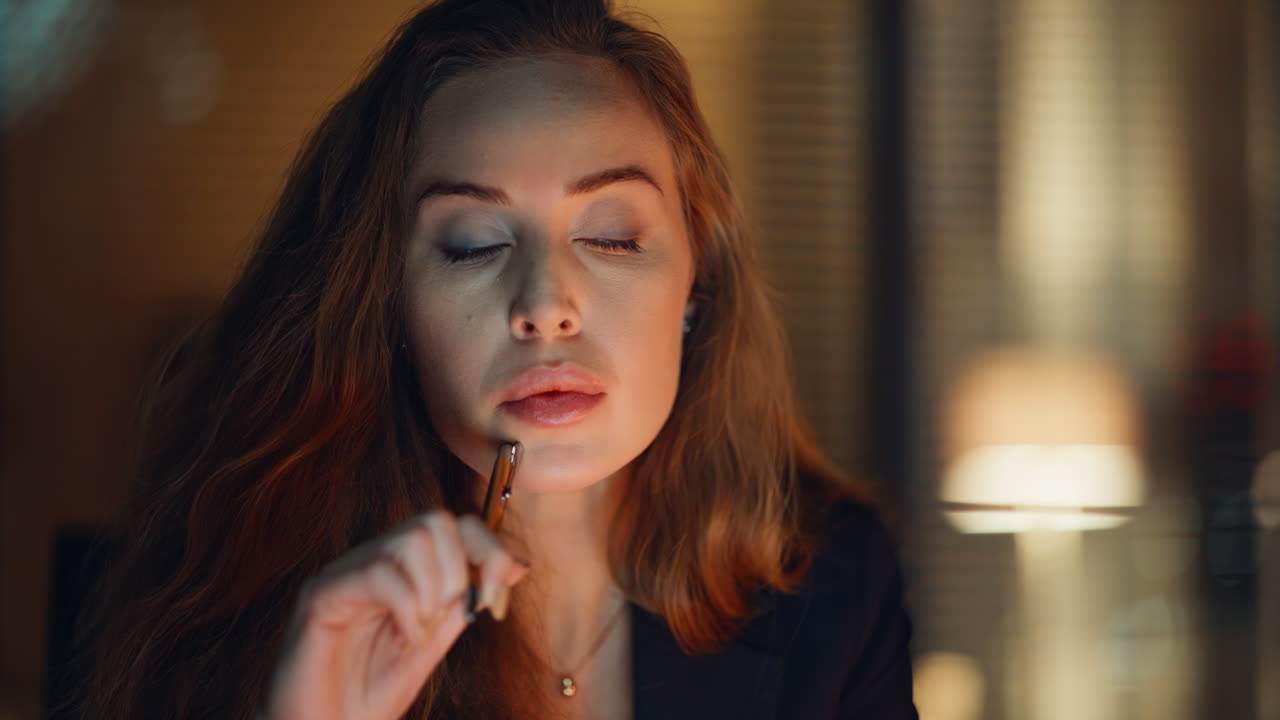 Closeup pensive businesswoman working at night under lamp light. Thoughtful lady