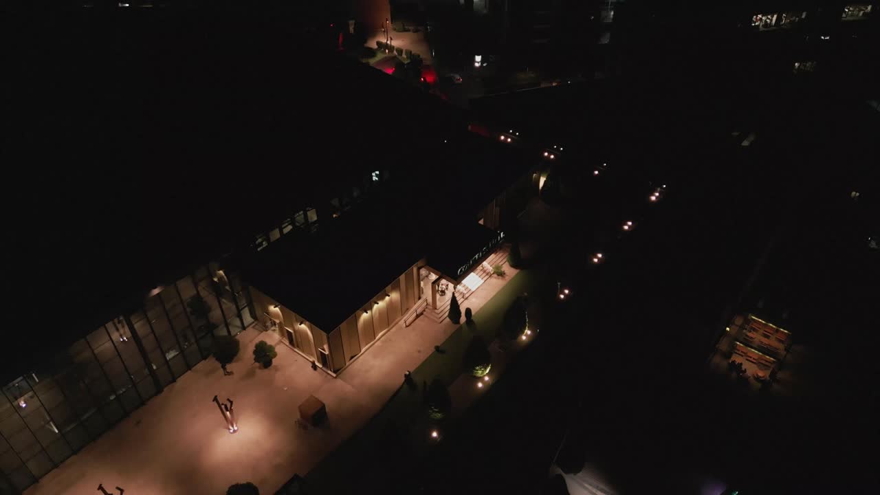 aerial falling away from Palas mixed-use development at night