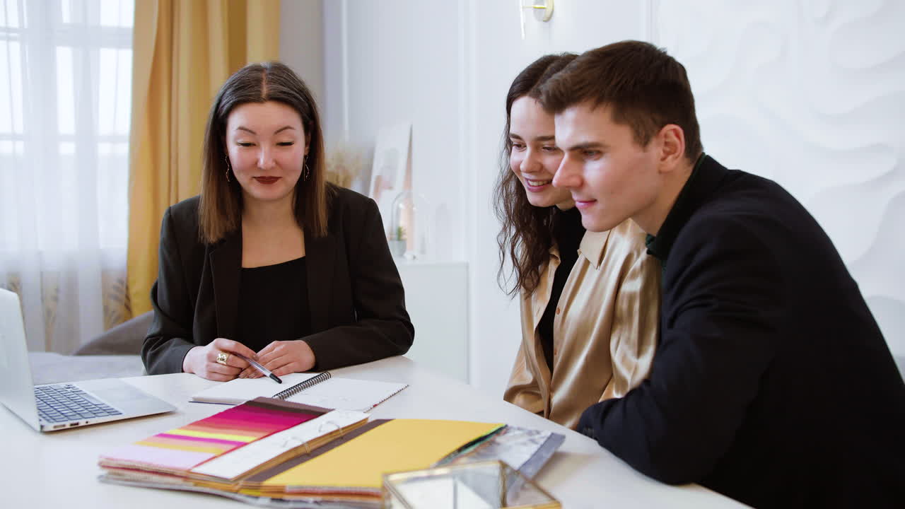 mujer asiática mostrando un libro de muestra a una pareja