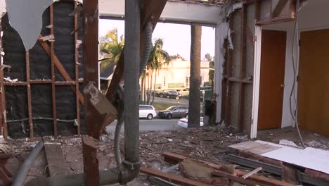 Los-Autos-Pasan-Por-La-Calle-Frente-A-Una-Casa-En-Proceso-De-Demolición.