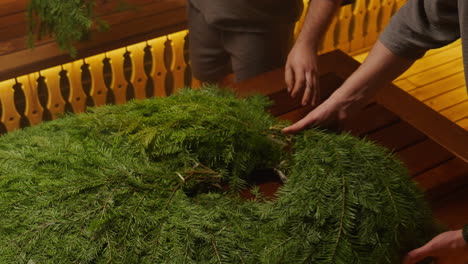 preparing a christmas fir wreath in a sauna