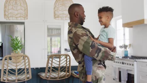 feliz padre afroamericano y su hijo abrazándose y sonriendo