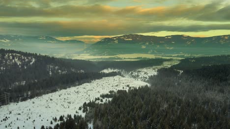 Awe-Inspiring-Mountain-Scenery-with-Powerlines-in-Winter-Snow:-Aerial-tracking-Shot