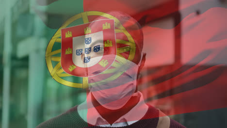 animation of flag of portugal waving over man wearing face mask during covid 19 pandemic