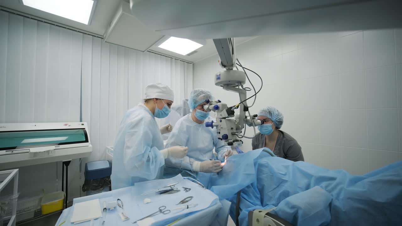 Surgery team making strabismus surgery using modern technologies, latest devices, microscope in modern clinic