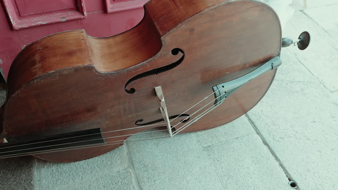 worn cello lying on ground evokes rustic musical atmosphere