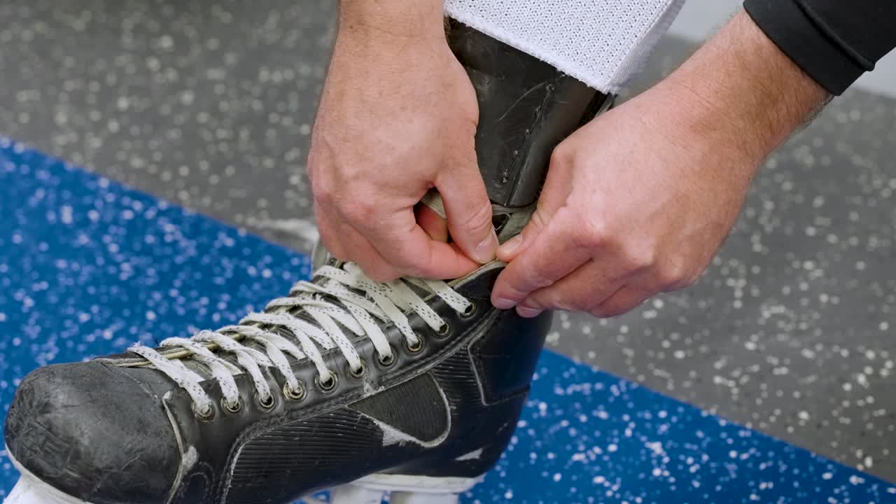 Giocatore di hockey che si allaccia i pattini da hockey prima dell'allenamento