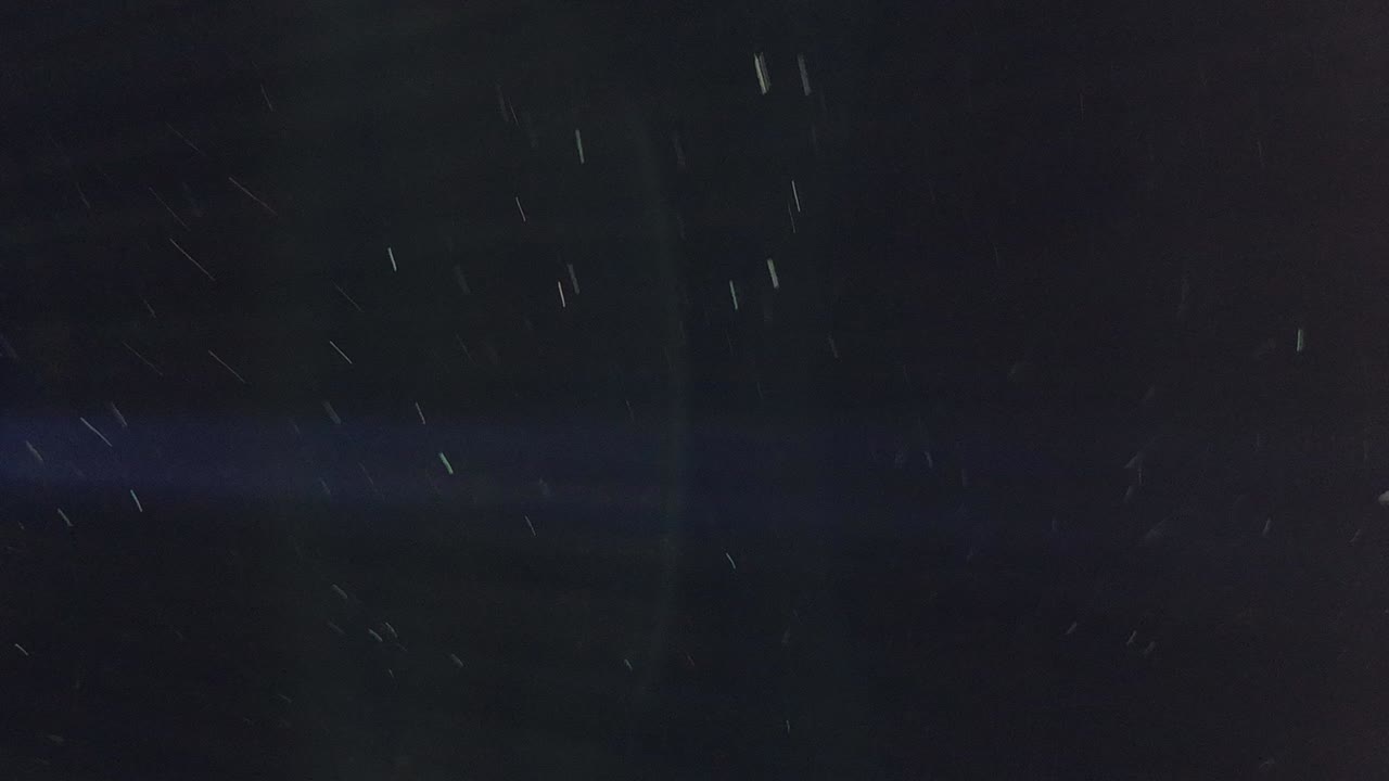 검은 배경 조명에 빠르게 움직이는 먼지 입자