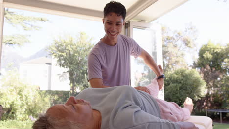 physiotherapist assisting senior woman with leg exercise during therapy session