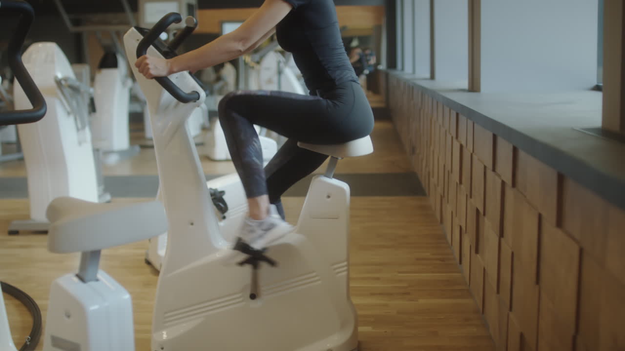 Woman exercising on a stationary bike in a modern gym