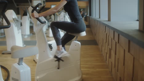 woman exercising on a stationary bike in a modern gym
