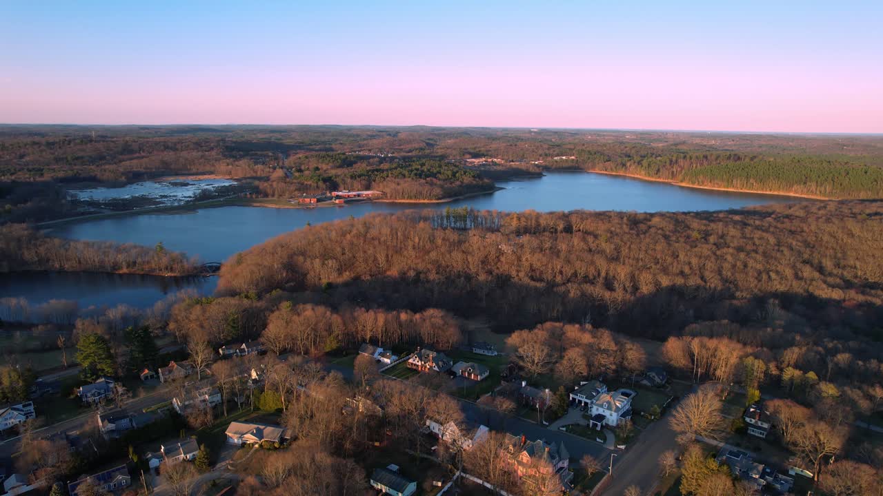 Aerial view of quiet New England neighborhood and leafless forest at dusk, Haverhill, Massachusetts, USA
