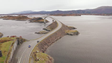 aerial orbit of atlantic ocean road with cars crossing storseisundet bridge, norway