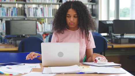female student working on computer in college library