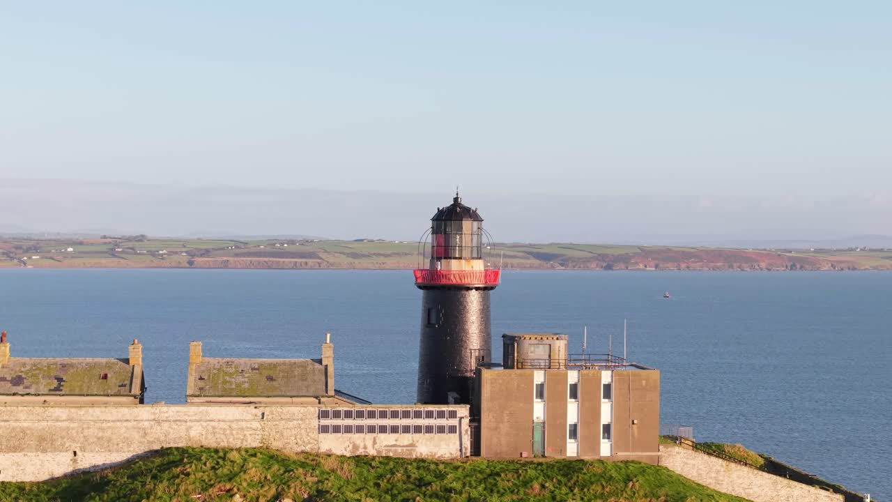 Ballycotton Lighthouse with scenic sea view in County Cork, Ireland, under bright skies