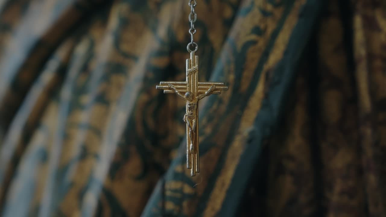 Primer plano de un colgante de crucifijo dorado con fondo ornamentado