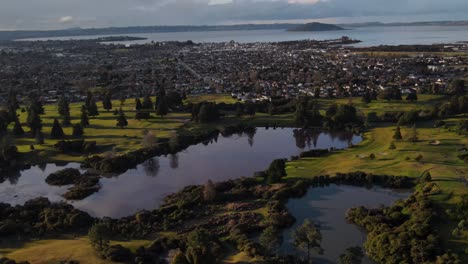 Geothermal-Pools-Of-Rotorua-Golf-Club-In-Whakarewarewa,-New-Zealand-With-Rotorua-Caldera-And-Mokoia-Island-In-Background