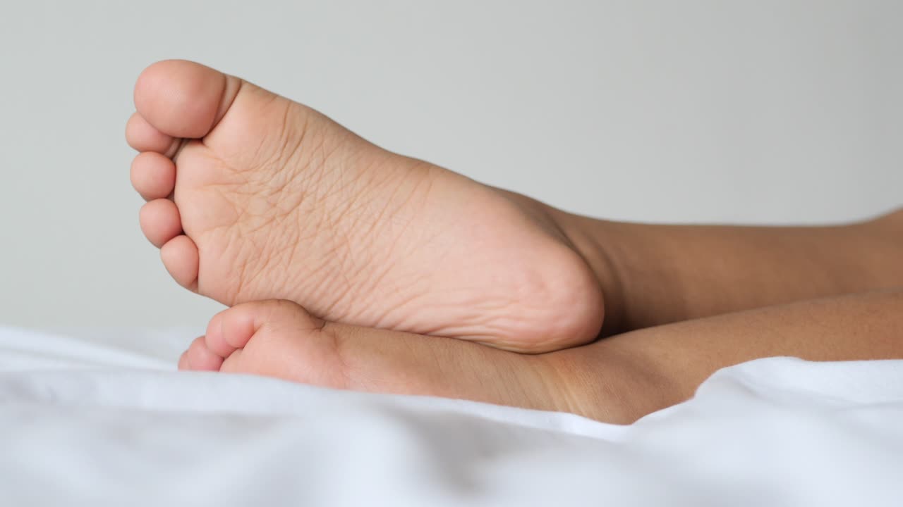 5살짜리 아이의 발이 침대에 마른 상태입니다.