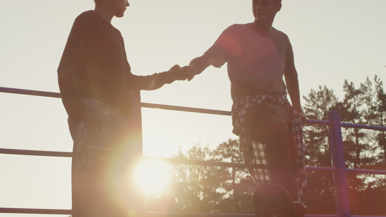 Teenagers with Skateboards Fist Bumping