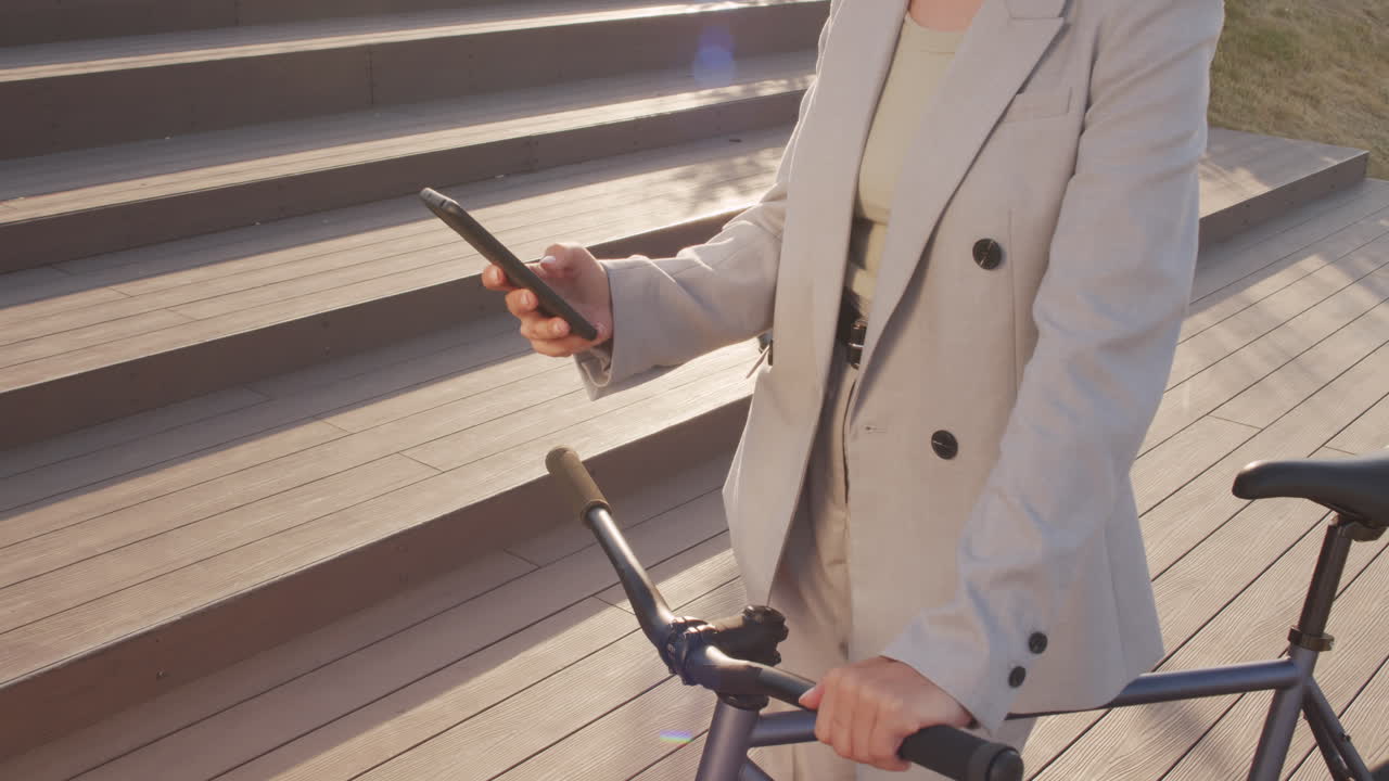 Woman with Bike Scrolling on Smartphone Outdoors