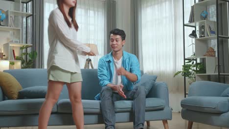 frustrated asian couple after checking a pregnancy test in living room at home