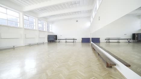 a sports hall in public high school with huge mirrors on the wall