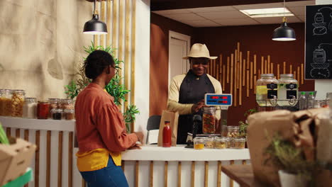 african american seller preparing bag with products for client