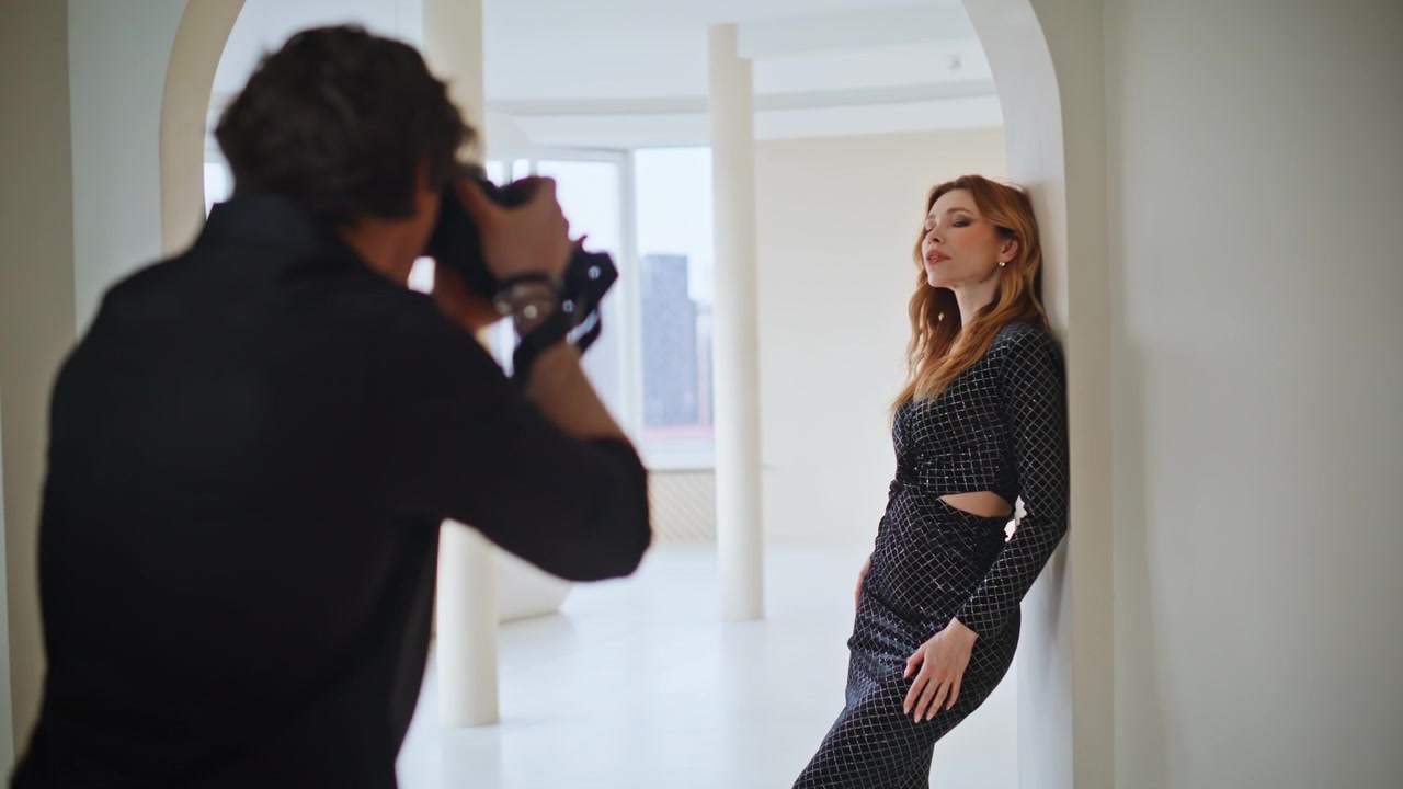 Fotógrafo dirigindo modelo em sessão de estúdio. Homem ajustando a pose em apartamento de luxo
